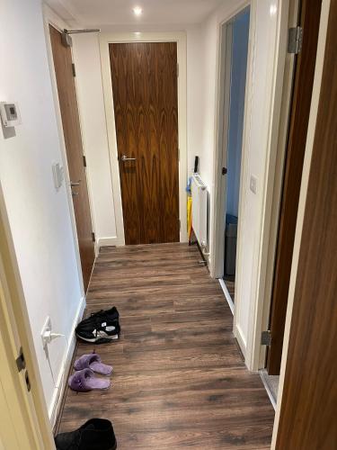 a hallway with shoes on the floor next to a door at Modern/Spacious Apartment in Digbeth (5 minute walk from Bullring) in Birmingham