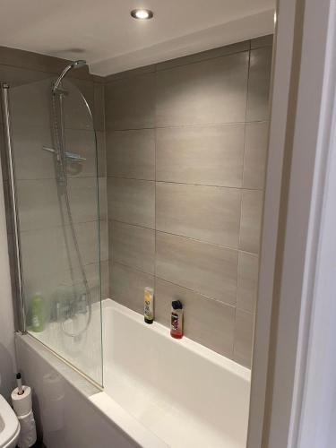 a bathroom with a shower and a bath tub at Modern/Spacious Apartment in Digbeth (5 minute walk from Bullring) in Birmingham