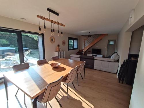 ein Esszimmer und ein Wohnzimmer mit einem Holztisch und Stühlen in der Unterkunft Villa en bord de mer in Jullouville-les-Pins