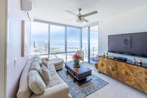a living room with a large couch and a flat screen tv at Luxury Residence at Kakaako in Honolulu