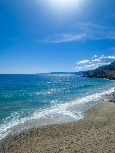 a beach with the ocean and a blue sky at Varigotti Tropical Garden - full floor apartment in Varigotti