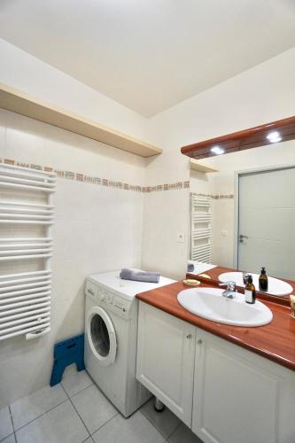 une salle de bain avec une machine à laver et un lavabo dans l'établissement L'Amirage * à 200m de la mer*, à Ploemeur
