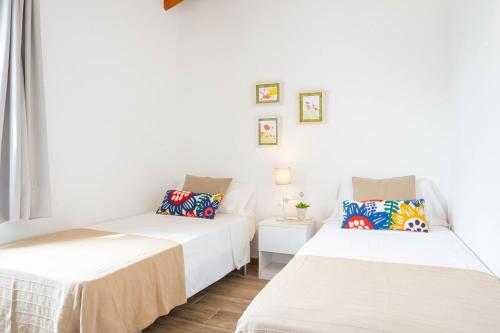 2 camas en una habitación con paredes blancas en Apartamento Calan Bosch, Ciutadella en Cala'n Bosch