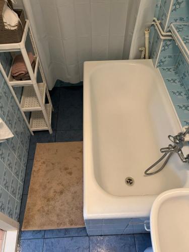 a white bath tub in a bathroom with a sink at Apartament Kackówka in Gdynia