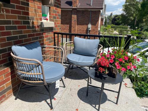 two chairs and a table with flowers on a patio at The Rustic Barn in Brampton