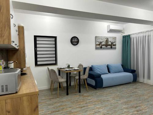 - un salon avec un canapé bleu et une table dans l'établissement Daniel Apartment, à Năvodari