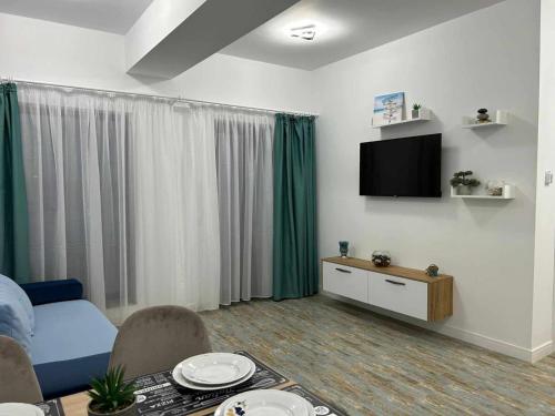 - un salon avec un canapé et une télévision dans l'établissement Daniel Apartment, à Năvodari