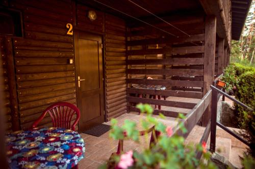 a small wooden cabin with a table and a chair at Komáří Louka in Nová Olešná