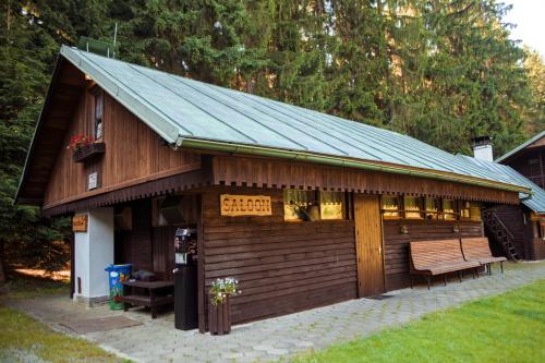 a small building with a bench in a yard at Komáří Louka in Nová Olešná
