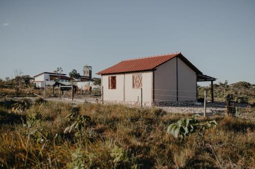 a small white house on a hill in a field at Paradise Ranch Chapada dos Veadeiros in Alto Paraíso de Goiás