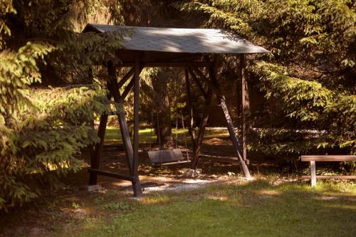 a picnic shelter with a bench in a park at Komáří Louka in Nová Olešná