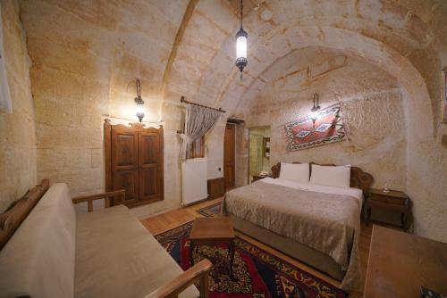 a bedroom with a large bed in a stone room at Fairyland Cave Hotel in Goreme