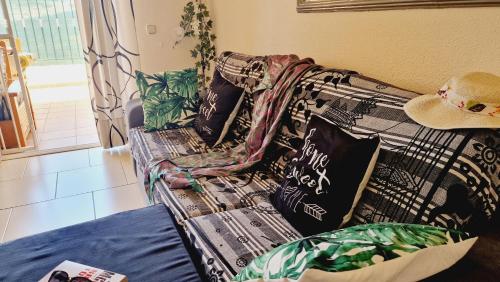 eine Couch im Wohnzimmer mit Hut drauf in der Unterkunft Mareverde holiday's, 1 room & big terrace in Adeje