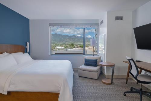 um quarto de hotel com uma cama, uma secretária e uma janela em Element Colorado Springs Downtown em Colorado Springs