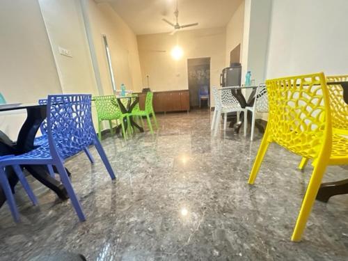 a dining room with colorful chairs and tables at Classic Hotel in Shamshabad