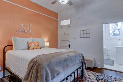 1 dormitorio con 1 cama y una bicicleta en la pared en NEW! Orange Street Downtown Cottage en Hot Springs