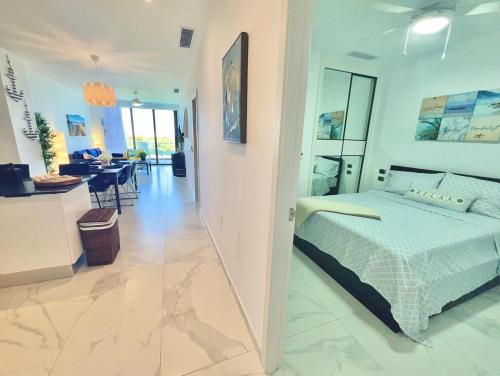 a bedroom with a bed and a dining room at Cana Rock Star, Apartamento Lujo Vista Golf Infinity Pool A-410 in Punta Cana