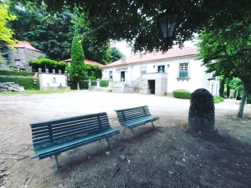 two blue benches sitting in front of a building at Casa das Feitorias Douro Valley in Baião
