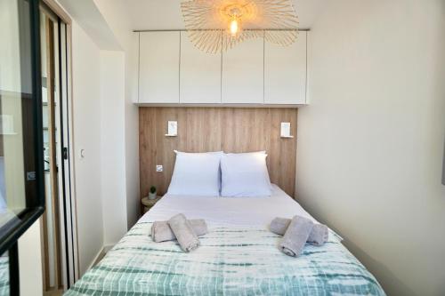 ein Schlafzimmer mit einem Bett mit zwei Kissen darauf in der Unterkunft Rose des sables * front de mer* in Ploemeur