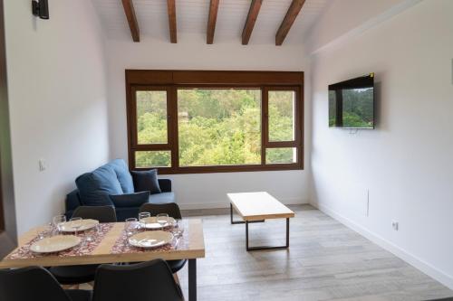 een woonkamer met een tafel en stoelen en een raam bij La Mina de Vega 