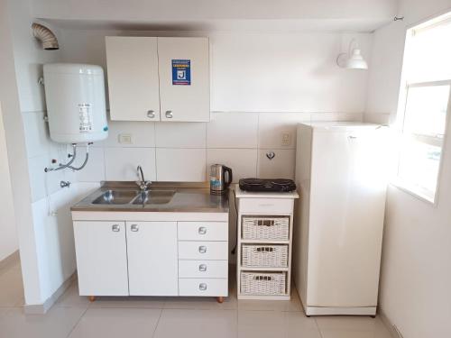a small kitchen with a sink and a refrigerator at Atardeceres in Resistencia