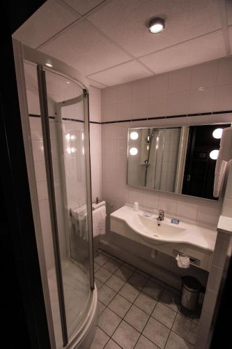 un baño con ducha y lavabo en Hotel Bollaert, en Lens