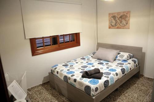 ein Schlafzimmer mit einem Bett in einem Zimmer in der Unterkunft Amplia casa 5 habitaciones en Santa Cruz con zona para trabajar in Santa Cruz de Tenerife