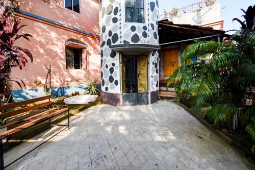a building with a gate and a building with a courtyard at Hotel O Adorini Guest House in Shānti Niketan