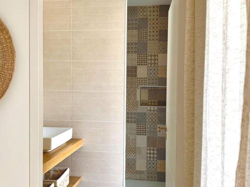 uma casa de banho com um lavatório e um chuveiro em Maison Mèze, 6 pièces, 8 personnes - FR-1-604-43 em Mèze