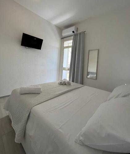 Habitación blanca con cama y ventana en Central Rooms Posada, en Posada