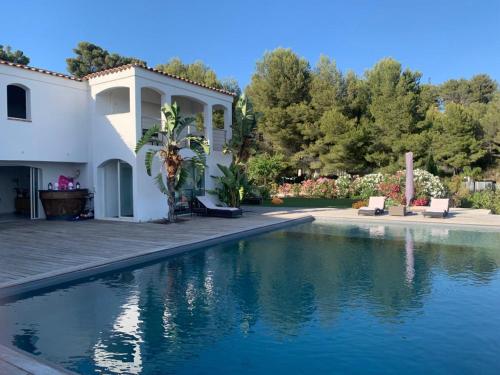 a house with a swimming pool in front of it at Villa vue mer et pinède in Bandol