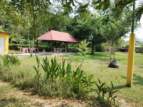 a gazebo with a red roof in a park at Garden Suites Comalcalco in Comalcalco