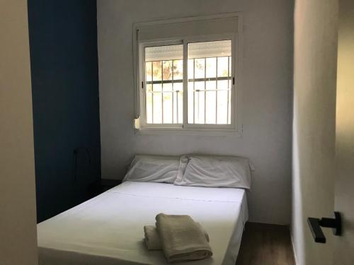 a white bed in a room with a window at Los Pinos in Alginet