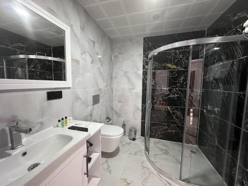 a bathroom with a shower and a sink and a toilet at White Life Hotel & Cafe in Bitlis