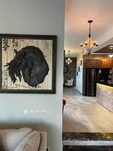 a living room with a picture of a horse on the wall at Luxury villa in seachell sahel el alamein in Sīdī ‘Abd ar Raḩmān