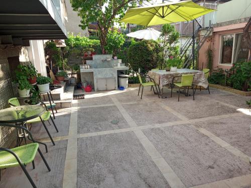 a patio with a grill and chairs and an umbrella at Guest House Radoychevi in Velingrad