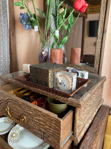 a dresser with a mirror and a table with plates at Riad Azurite in Chefchaouene