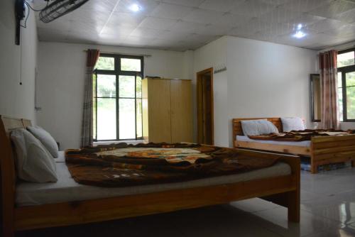 a bedroom with two beds in a room with windows at Eagle Nest, Malam Jabba by LMC in Swat