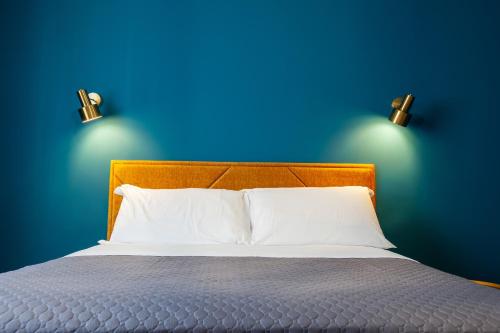 a bed with two lights on a blue wall at Malù - Bed & Breakfast in Agrigento