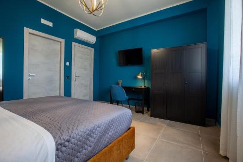a bedroom with blue walls and a bed and a desk at Malù - Bed & Breakfast in Agrigento