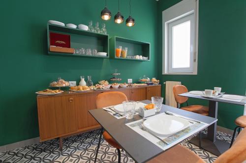 a dining room with green walls and a table and chairs at Malù - Bed & Breakfast in Agrigento