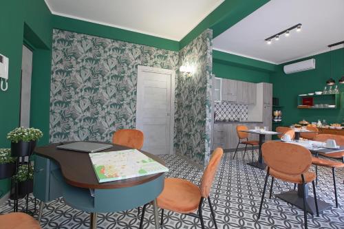 a dining room with green walls and orange chairs at Malù - Bed & Breakfast in Agrigento