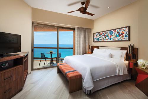 - une chambre avec un grand lit et une télévision dans l'établissement The Westin Los Cabos Resort Villas, à San José del Cabo