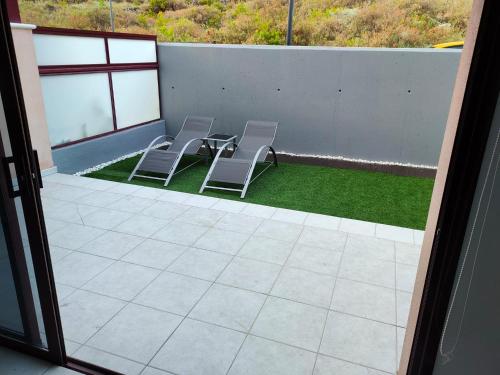 2 sillas y una mesa en un patio con césped en Home2Book Casita Frontera Wonderful Terrace, en La Frontera