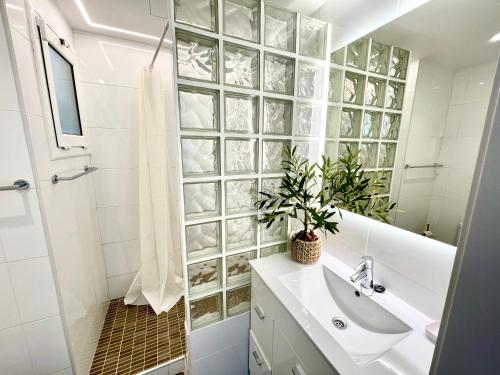 y baño con lavabo y ducha. en SeaHomes Vacations - MARINA BOUTIQUE design, en Santa Susanna
