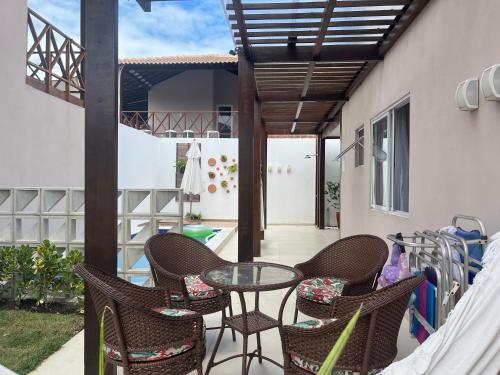 Un patio con sillas y una mesa en el balcón. en Bangalô 39 en Tamandaré