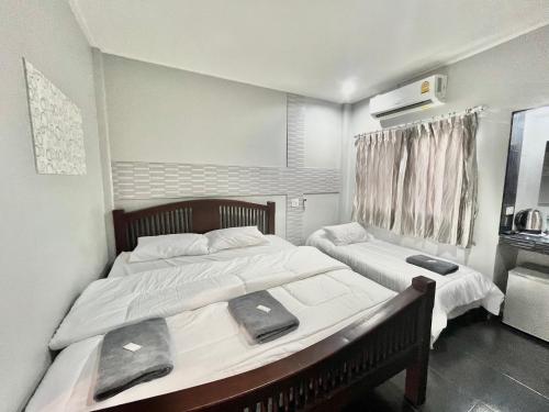 1 dormitorio con 2 camas con sábanas blancas en J2 INN, en Uttaradit