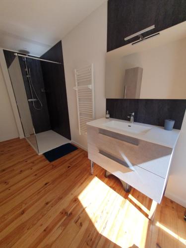 a bathroom with a white sink and a shower at Appartement chic et cosy in Authézat