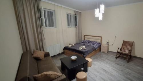 GumbaHouse في تبليسي: غرفة معيشة مع سرير وأريكة