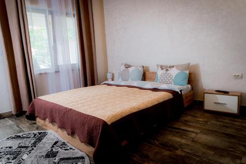 1 dormitorio con 1 cama grande con almohadas y ventana en Pescarul Deltei, en Murighiol